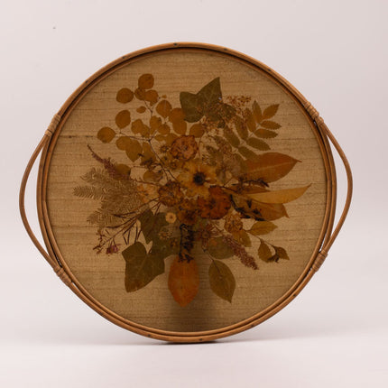 Plateau vintage rond à anses en rotin avec un fond en fleurs séchées