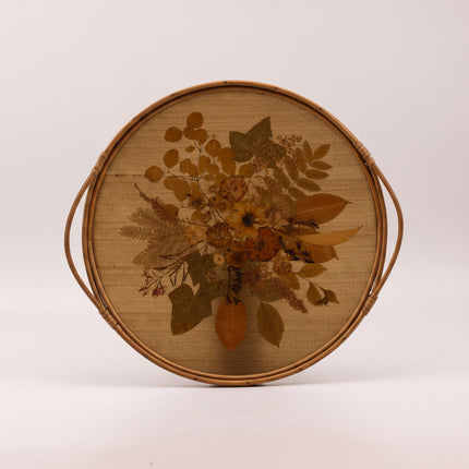 Plateau vintage rond à anses en rotin avec un fond en fleurs séchées