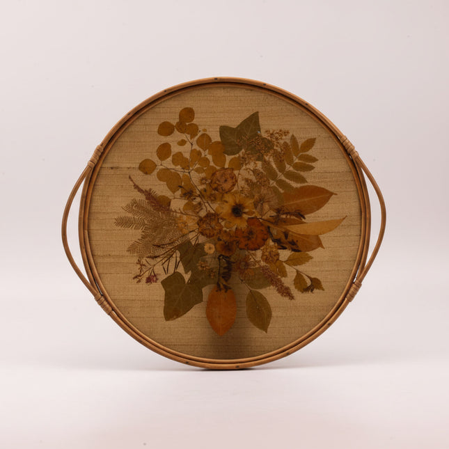 Plateau vintage rond à anses en rotin avec un fond en fleurs séchées