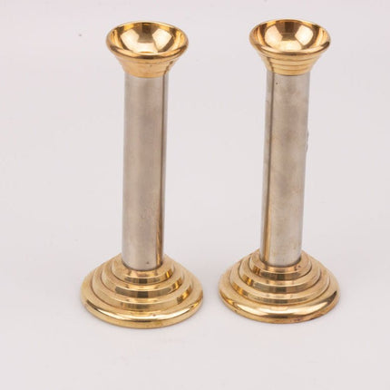 Een paar vintage zilveren en gouden metalen kandelaars