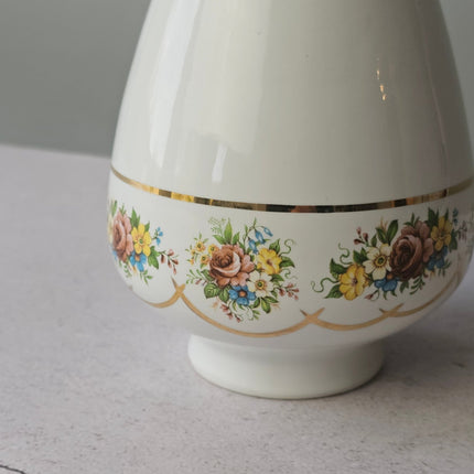 Witte porseleinen vaas uit Brussel met gouden rand en bloemen.